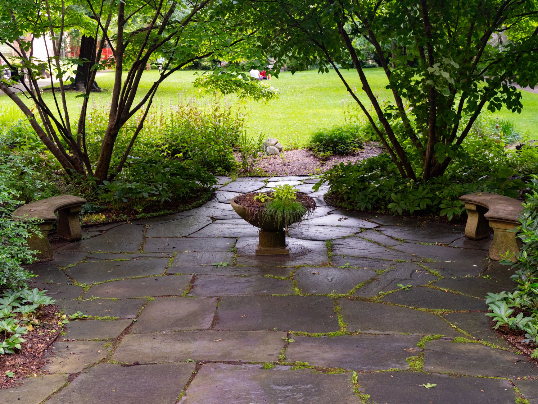 Flagstone patio surrounded by garden greenery