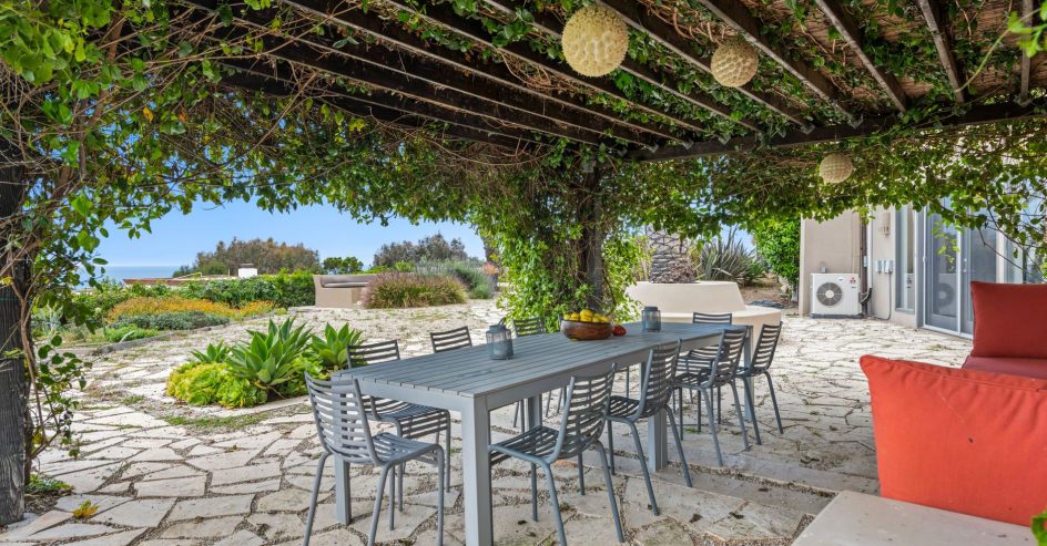 Flowering climbing vines covering a wooden pergola in a New Orleans backyard