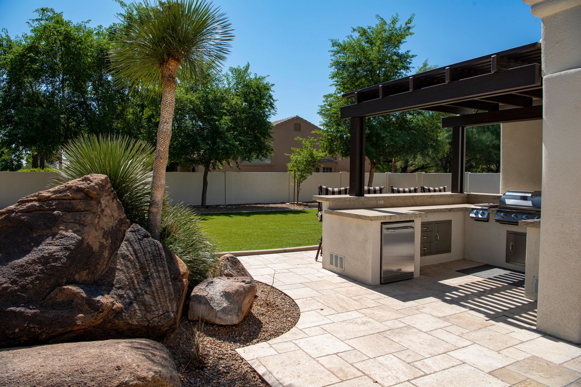 Covered outdoor kitchen with pergola roof in a New Orleans backyard