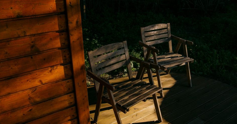 Well-maintained wood deck in a lush New Orleans backyard under warm sunlight