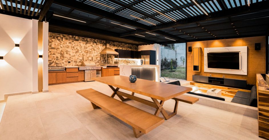 Modern outdoor kitchen with built-in grill, stone countertops, and bar seating adding home value in New Orleans