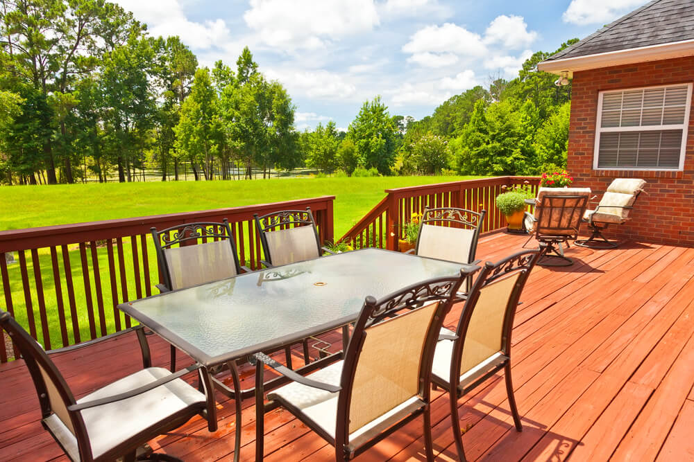 Wood deck with outdoor dining set built by Big Easy Outdoor Design in the New Orleans metro