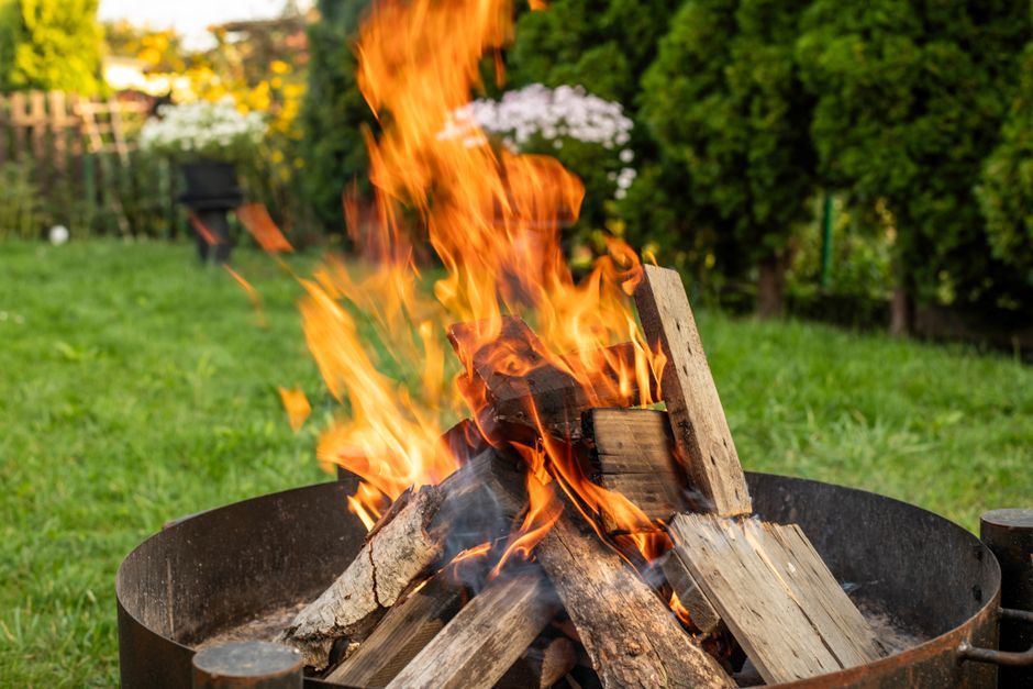 Content image 2  - A wood-burning fire pit with stacked firewood nearby