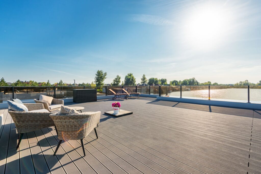 Modern deck boards laid across a shaded outdoor seating area beside water