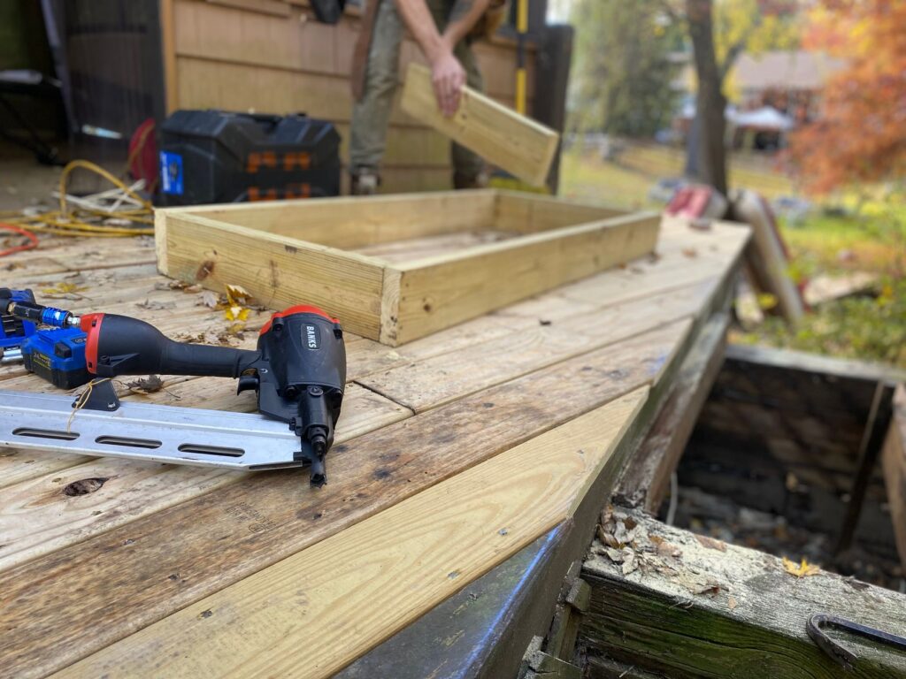 Carpenter fastening deck boards to a timber frame during construction
