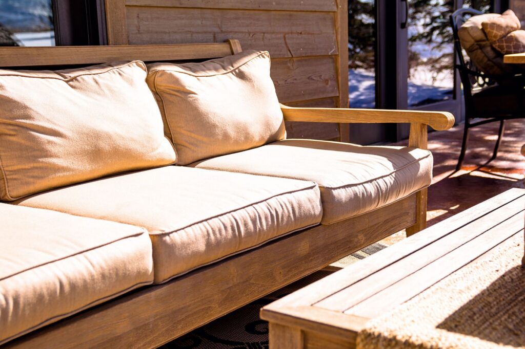 Cushioned timber outdoor sofa on a covered patio