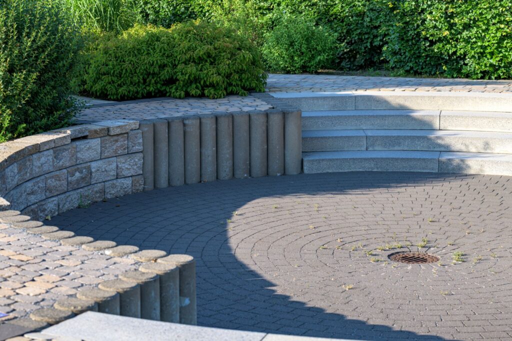 Curved paver patio finished with a retaining wall, steps and edging