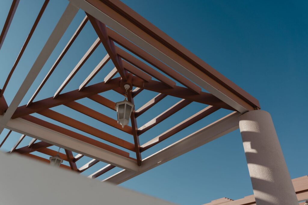 Pergola beams and posts viewed from below, the structural elements a permit review covers