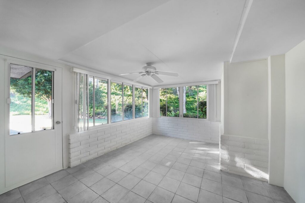 Sunroom with ceiling fan and shaded windows keeping the space cool in summer