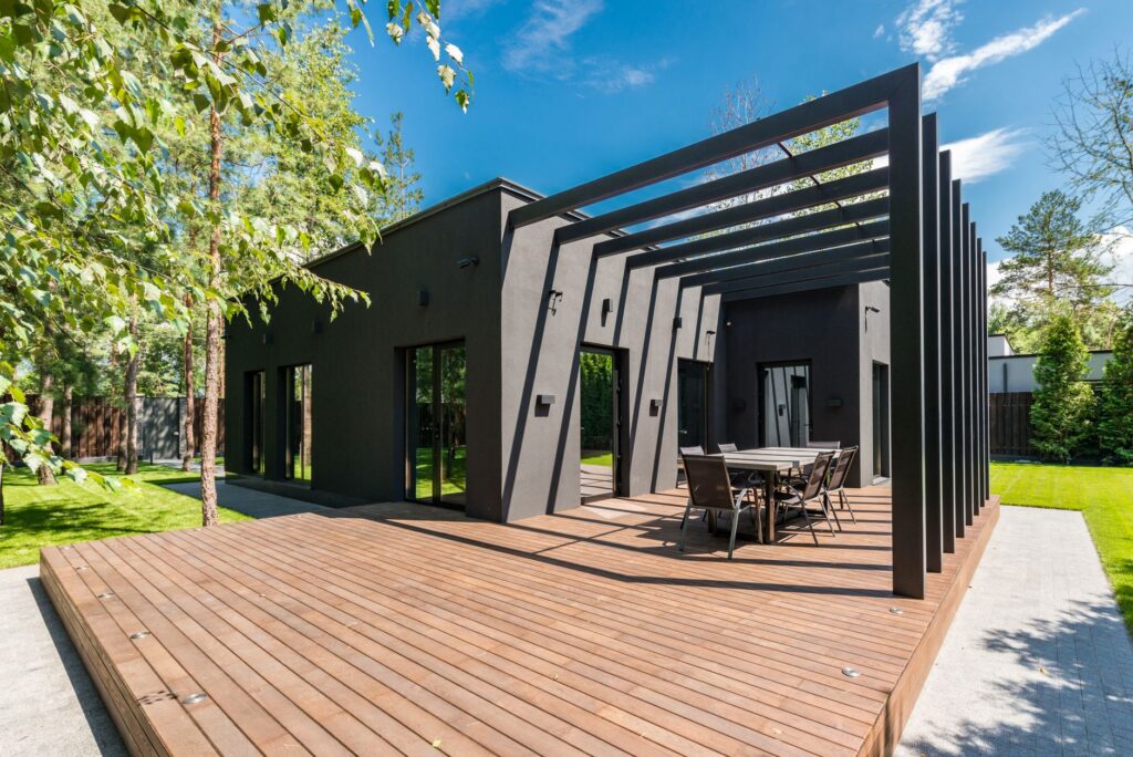 Modern home with a timber deck and a slatted overhead structure providing shade
